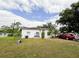 Front yard view of a white single-story house with a red car parked nearby at 2109 Morning Dr, Orlando, FL 32809