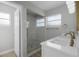 Elegant bathroom with marble shower, dual sinks, and gold fixtures at 26603 W Cove Dr, Tavares, FL 32778