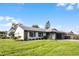 Newly renovated home with gray exterior, stone accents, and a large green yard at 26603 W Cove Dr, Tavares, FL 32778