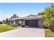 Updated single-story home with stone facade, gray exterior and screen enclosure at 26603 W Cove Dr, Tavares, FL 32778