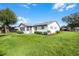 Single story home with gray exterior, landscaping, and spacious yard at 26603 W Cove Dr, Tavares, FL 32778