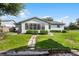 Rear view of home with sunroom and manicured lawn at 26603 W Cove Dr, Tavares, FL 32778