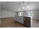 Kitchen island with white cabinets and quartz countertops, open to adjoining living area at 26603 W Cove Dr, Tavares, FL 32778