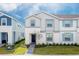 Two-story townhome with gray and blue siding, a paved walkway, and a well-maintained lawn at 281 Jetty Way, Davenport, FL 33897