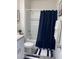 Modern bathroom featuring a white bathtub and navy shower curtain at 310 Gardenia Ct, Poinciana, FL 34759
