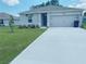 Single-story home with a two-car garage and well-manicured lawn at 310 Gardenia Ct, Poinciana, FL 34759