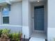 Inviting home exterior with a dark gray front door and well-manicured landscaping at 310 Gardenia Ct, Poinciana, FL 34759