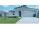 Single-story house with attached garage, landscaping, and driveway at 310 Gardenia Ct, Poinciana, FL 34759