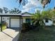 White house with teal door, carport, and landscaped yard at 4171 Radford Rd, Bartow, FL 33830
