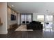 Modern living room with dark hardwood floors, a large sectional sofa, and a built-in media wall at 15614 Espalier Way, Winter Garden, FL 34787