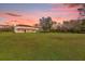 Two-story house with red tile roof, set on a large lot at sunset at 19206 Robertson St, Orlando, FL 32833