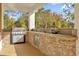 Stone outdoor kitchen with built-in grill and sink, perfect for entertaining at 19206 Robertson St, Orlando, FL 32833
