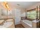Elegant bathroom with double sinks, soaking tub, and walk-in shower at 3006 Seaview Castle Dr, Kissimmee, FL 34746