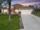 House exterior featuring a one-car garage and landscaping at 552 Eagle Ct, Poinciana, FL 34759