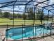 Screened pool with a basketball hoop and safety fence at 8956 Hilton Ridge Ave, Kissimmee, FL 34747