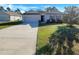 One-story home with gray siding, a two-car garage, and a well-manicured lawn at 127 Hickory Crse, Ocala, FL 34472