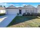 One-story home with gray siding, a two-car garage, and a well-manicured lawn at 127 Hickory Crse, Ocala, FL 34472