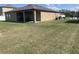 Large backyard with covered patio and ample grassy area at 16344 Blooming Cherry Dr, Groveland, FL 34736