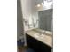 Modern bathroom with dark vanity, a shower, and updated fixtures at 16344 Blooming Cherry Dr, Groveland, FL 34736