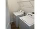 Bright laundry room with Whirlpool washer and dryer, and ample shelving at 16344 Blooming Cherry Dr, Groveland, FL 34736