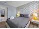 Bedroom with a queen-size bed, geometric patterned wall, and access to a bathroom at 1680 Moon Valley Dr, Davenport, FL 33896