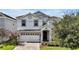 Two-story home with white exterior, gray accents, and a two-car garage at 1680 Moon Valley Dr, Davenport, FL 33896