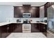 Modern kitchen features dark cabinetry, stainless steel appliances, and white countertops at 1680 Moon Valley Dr, Davenport, FL 33896
