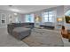 Open living room with a sectional sofa, large windows and a rug at 1680 Moon Valley Dr, Davenport, FL 33896