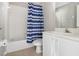 Clean bathroom with white vanity and blue striped shower curtain at 2711 Emerald Lake Ct, Kissimmee, FL 34744