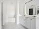 Bathroom with double vanity, a large mirror, and a white bathtub at 2711 Emerald Lake Ct, Kissimmee, FL 34744