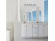 Bathroom with double vanity, a large mirror, and white cabinets at 2711 Emerald Lake Ct, Kissimmee, FL 34744