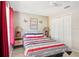 Bright bedroom with red and gray bedding and ceiling fan at 2711 Emerald Lake Ct, Kissimmee, FL 34744