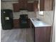 Modern kitchen with dark wood cabinets, black appliances, and a white countertop at 31541 Hillcrest Dr, Eustis, FL 32736