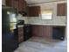Modern kitchen with dark wood cabinets and black appliances at 31541 Hillcrest Dr, Eustis, FL 32736