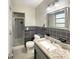 Bathroom with gray tile, granite vanity, and shower at 3700 Timber Trl, Orlando, FL 32808