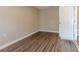 Simple bedroom with wood-look floors and an adjacent door at 5235 Botany Ct, Orlando, FL 32811