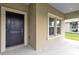 Dark front door and sidelights with a covered porch at 729 Hitch Loop, St Cloud, FL 34772