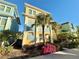 Three-story house with light-yellow walls, blue shutters, and palm trees at 8033 Surf St, Kissimmee, FL 34747