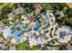 Aerial view of a resort-style pool area with multiple pools, a waterslide, and lush landscaping at 836 Desert Mountain Ct, Reunion, FL 34747