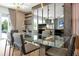 Modern glass dining table with gray chairs, located in open concept space at 836 Desert Mountain Ct, Reunion, FL 34747