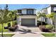 Modern two-story home with gray garage door and landscaped yard at 836 Desert Mountain Ct, Reunion, FL 34747