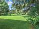Lush green backyard with mature trees and landscaping at 3904 Plantation Blvd, Leesburg, FL 34748