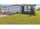 One story house with gray siding, brown roof and landscaped lawn at 4702 Jasmine Cir, Leesburg, FL 34748