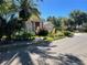 House with lush landscaping and palm trees on a tree-lined street at 4839 Eaglesham Dr, Orlando, FL 32826