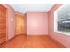 Simple bedroom with light pink walls and wood flooring at 6618 Abeydon Ct, Orlando, FL 32818