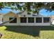 Tan house with screened porch and manicured lawn at 7922 Elmstone Cir, Orlando, FL 32822