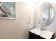 Modern bathroom with oval mirror, dark vanity, and updated fixtures at 875 Assembly Ct, Reunion, FL 34747