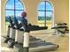 Modern gym with treadmills, weights, and large windows overlooking a golf course at 875 Assembly Ct, Reunion, FL 34747
