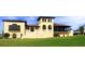 Two-story house with Spanish-style architecture, multiple balconies, and a manicured lawn at 875 Assembly Ct, Reunion, FL 34747