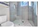 Modern bathroom with a large glass shower, gray tile, and white toilet at 1018 Wilks Ave, Belle Isle, FL 32809